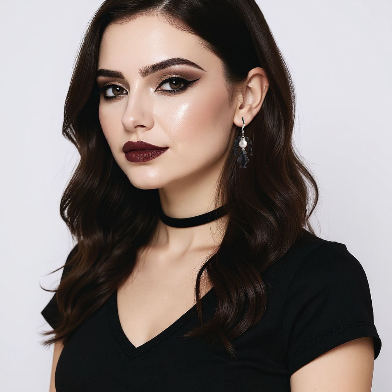 Woman wearing a black choker and earrings against a light background