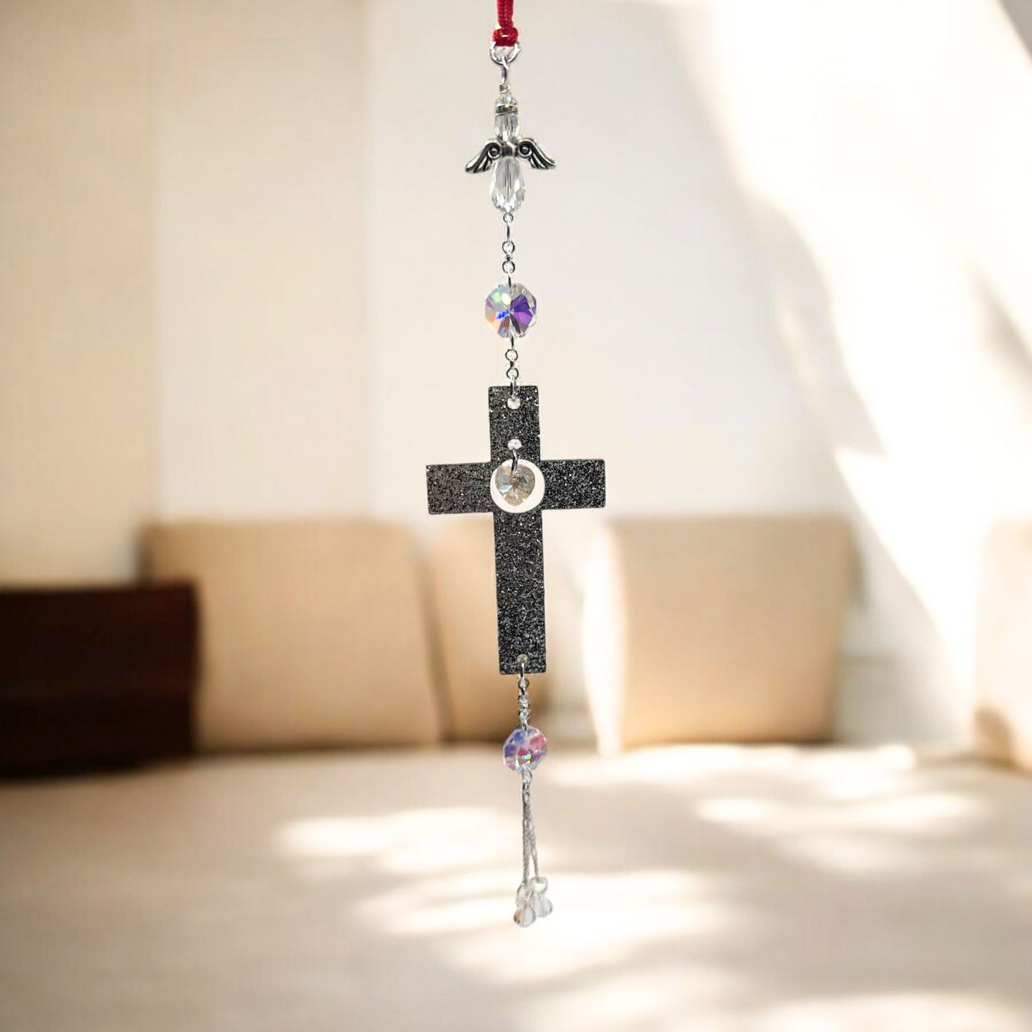 Decorative cross with beads hanging against a neutral background