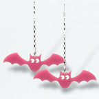 Pink bat-shaped earrings on silver chains against a white background