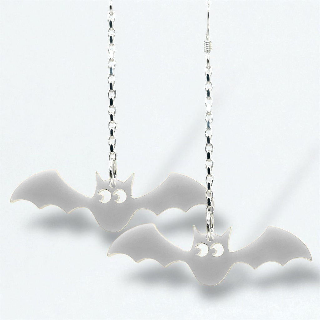Bat-shaped earrings on silver chains against a white background