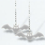 Bat-shaped earrings on silver chains against a white background