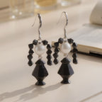 Pair of Wednesday Adams  Crystal beaded earrings on a light surface.