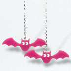 Pink bat-shaped earrings on silver chains against a white background