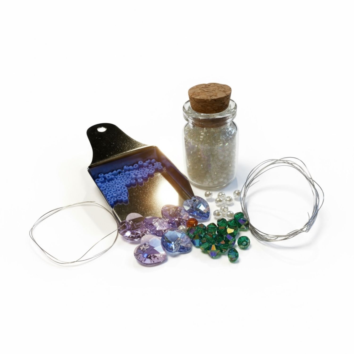 Jewelry-making supplies including beads, scoop, wire, and a small bottle on a white background