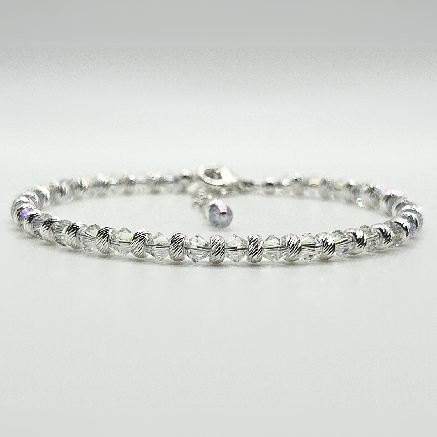 A completed bracelet made with the Endless Shimmer Bracelet Kit, featuring shimmering biconic beads, sterling silver beads, and a sterling silver clasp.
