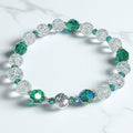 Beaded bracelet with green and clear beads on a white background