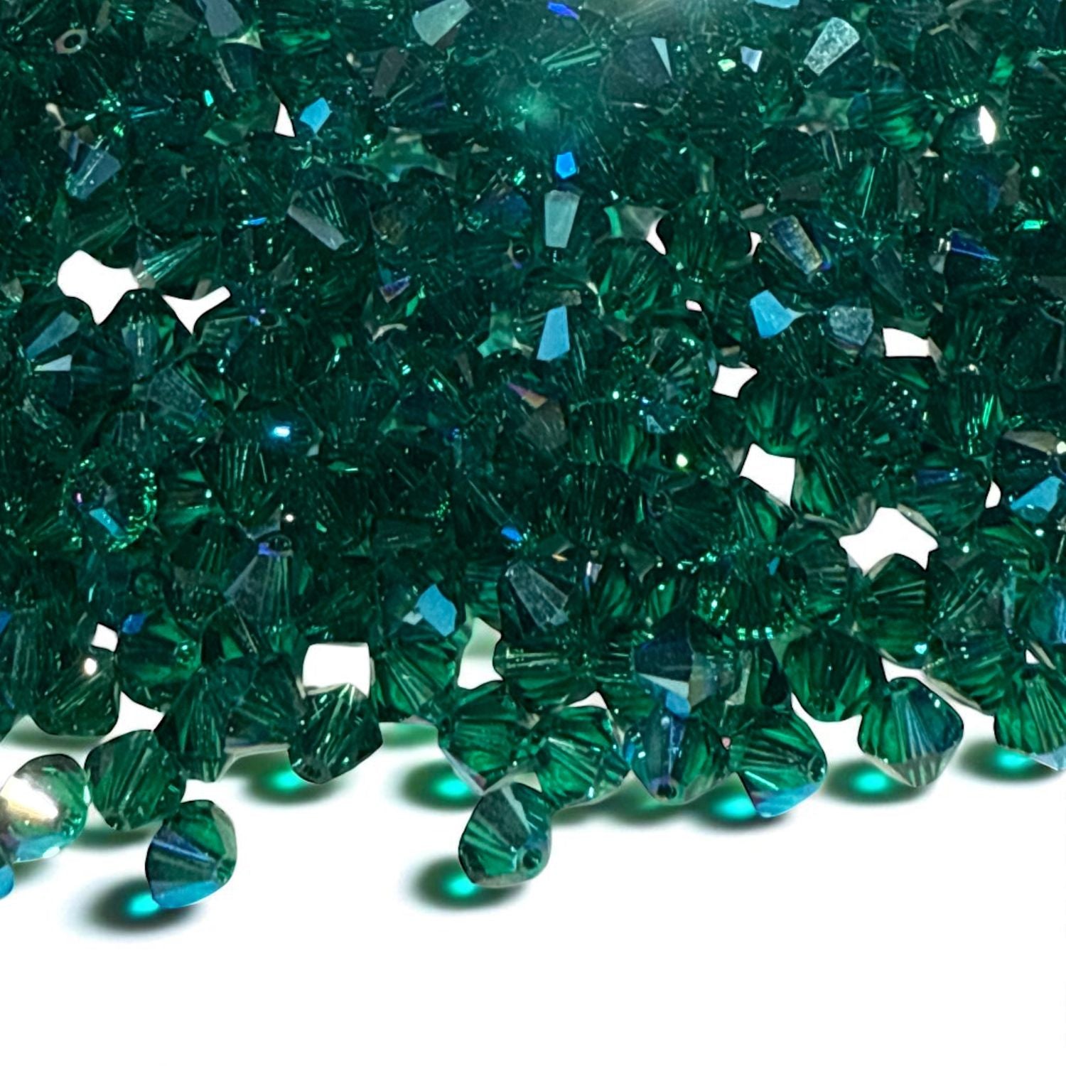 Green Swarovski crysta biconesl beads on a white background