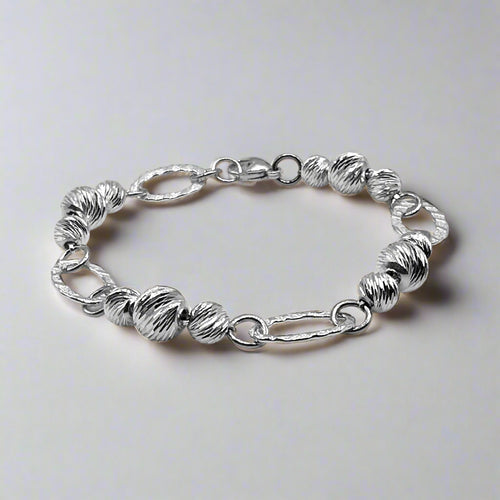 A completed sterling silver bracelet with a mix of round and link chains, displayed on a neutral background.