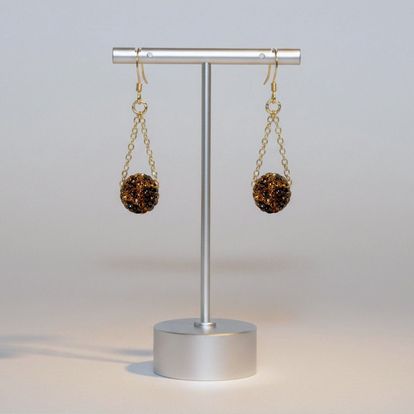 Pair of earrings on a stand against a light gray background