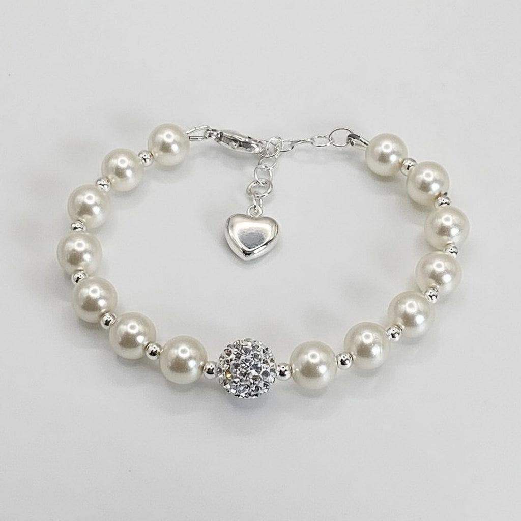 Pearl bracelet with a heart charm and round crystal bead on a light gray background