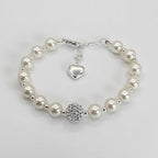 Pearl bracelet with a heart charm and round crystal bead on a light gray background