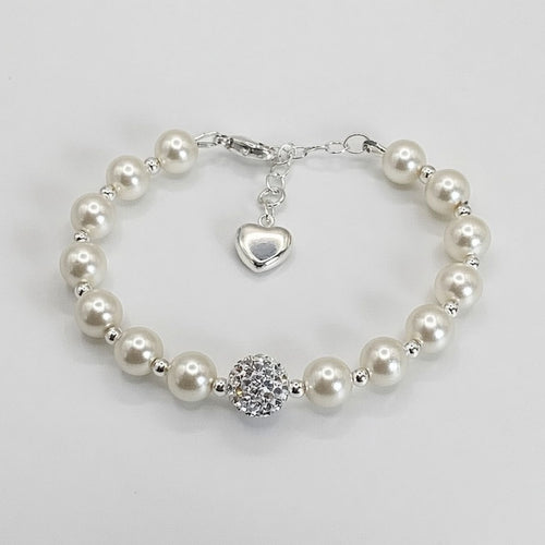 Pearl bracelet with a heart charm and round crystal bead on a light gray background