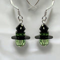 A pair of handmade Halloween-themed earrings featuring black and green crystal beads, designed to resemble the Wicked Witch.