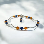 Beaded bracelet with blue and orange beads on a white background