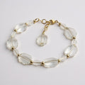 Clear crystal bracelet with gold accents on a light gray background