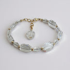 Crystal bracelet with gold accents on a light gray background
