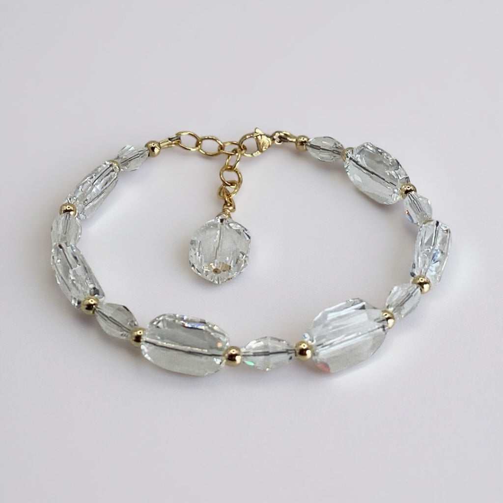 Crystal bracelet with gold accents on a light gray background