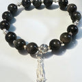 Black beaded bracelet with a silver tassel on a white background
