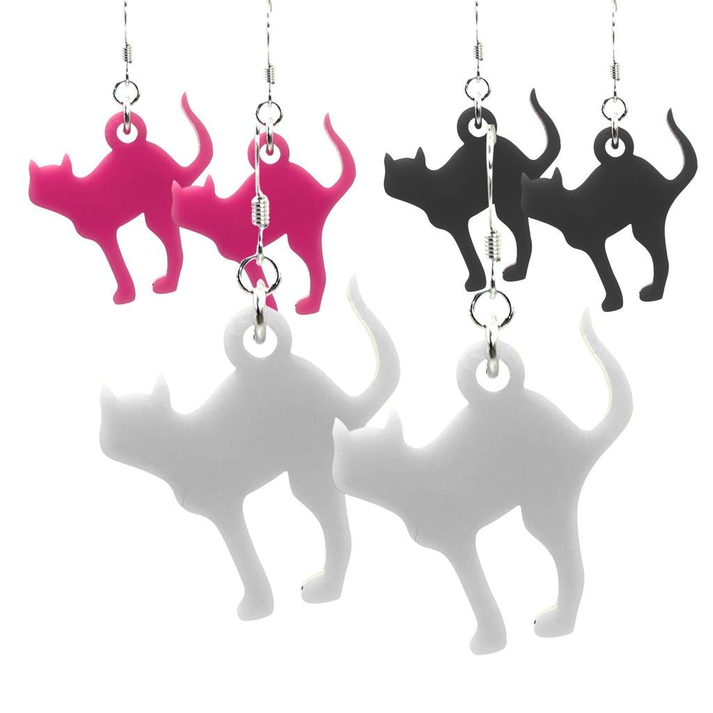 Cat-shaped earrings in pink, black, and white on a white background