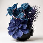Decorative flower arrangement and bracelet with blue and purple flowers on a white background