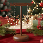 Wooden earring stand with Christmas-themed Crystal Rudolph earrings on a festive background with lights and decorations.