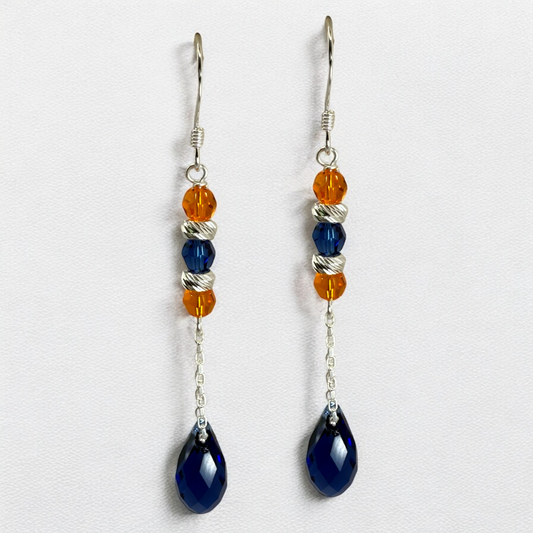 Pair of earrings with blue and orange beads on a white background