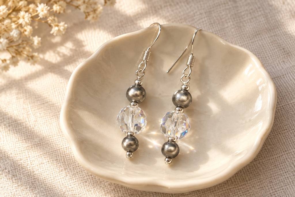 Crystal Moonlight and Navajo pearl earrings on an ivory dish and pale linen