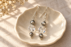 Crystal Moonlight and Navajo pearl earrings on an ivory dish and pale linen