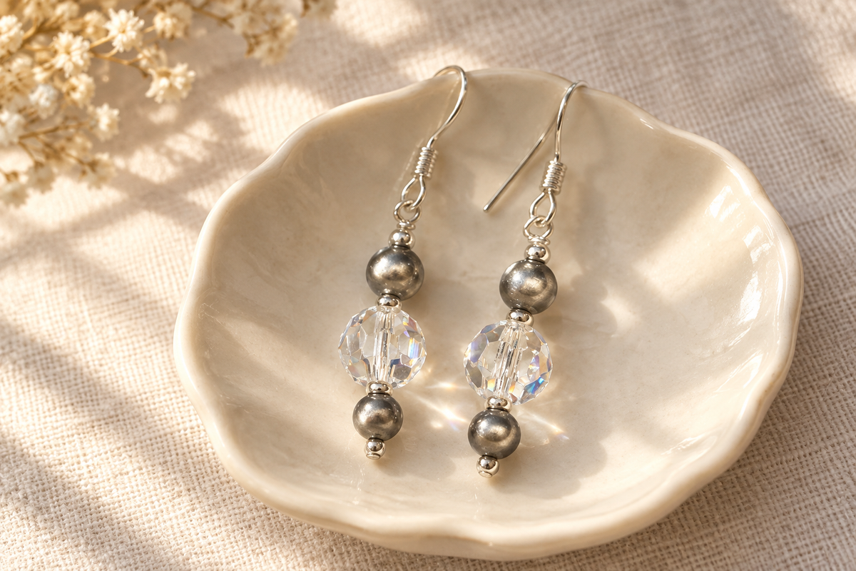 Crystal Moonlight and Navajo pearl earrings on an ivory dish and pale linen