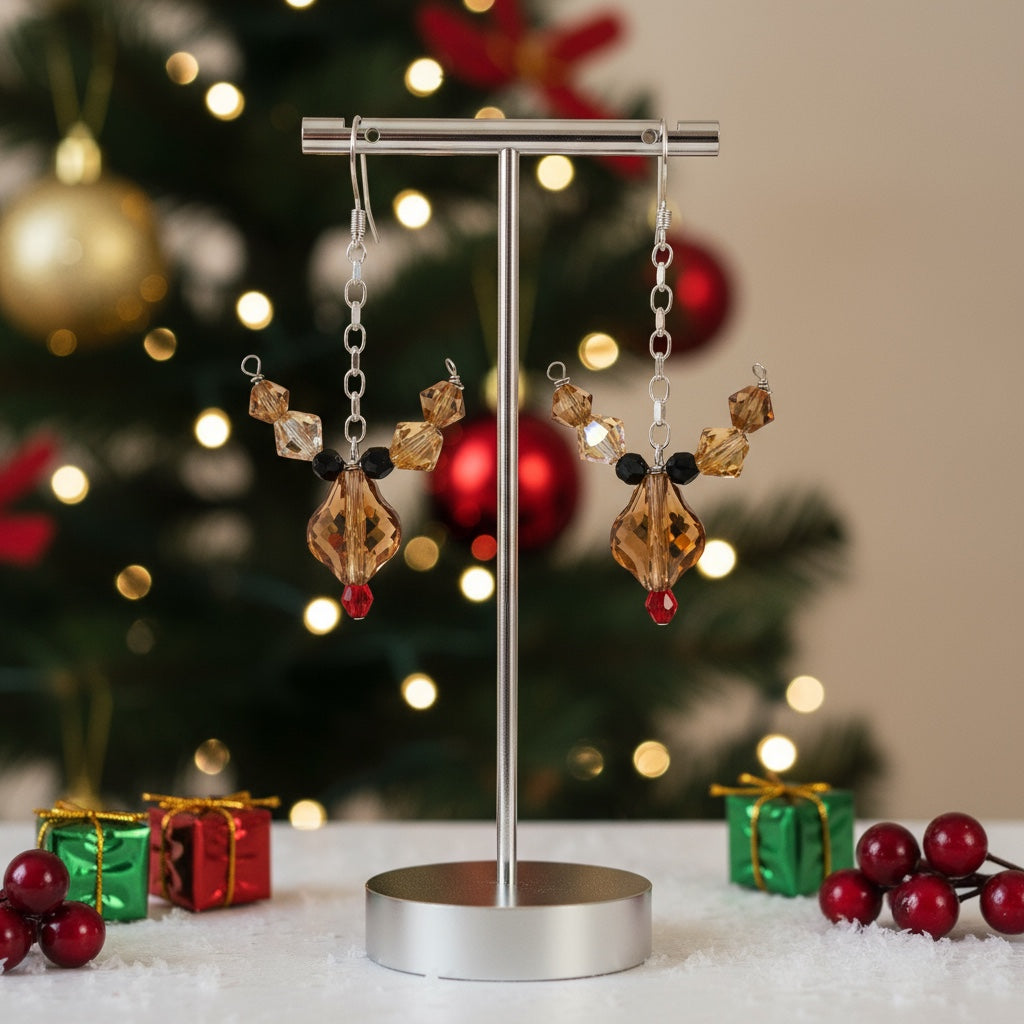 Earring display stand with decorative rudolph earrings in front of a Christmas tree.