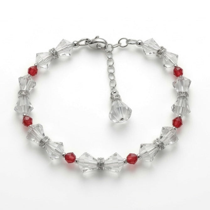 A beaded bracelet featuring faceted clear crystal beads and small red beads, arranged in a circle on a plain white background.